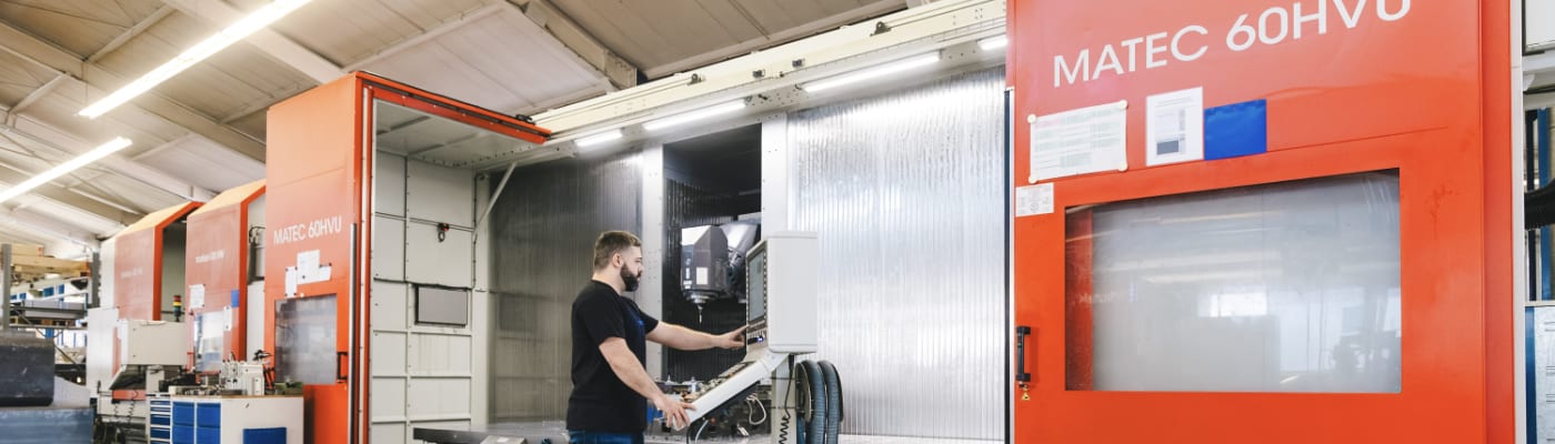 A man is standing in front of a large machine