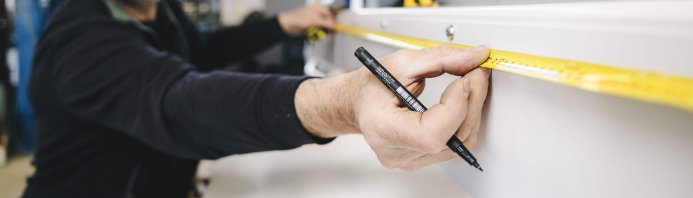 A man is holding a pen in his hand and is inspecting a machine