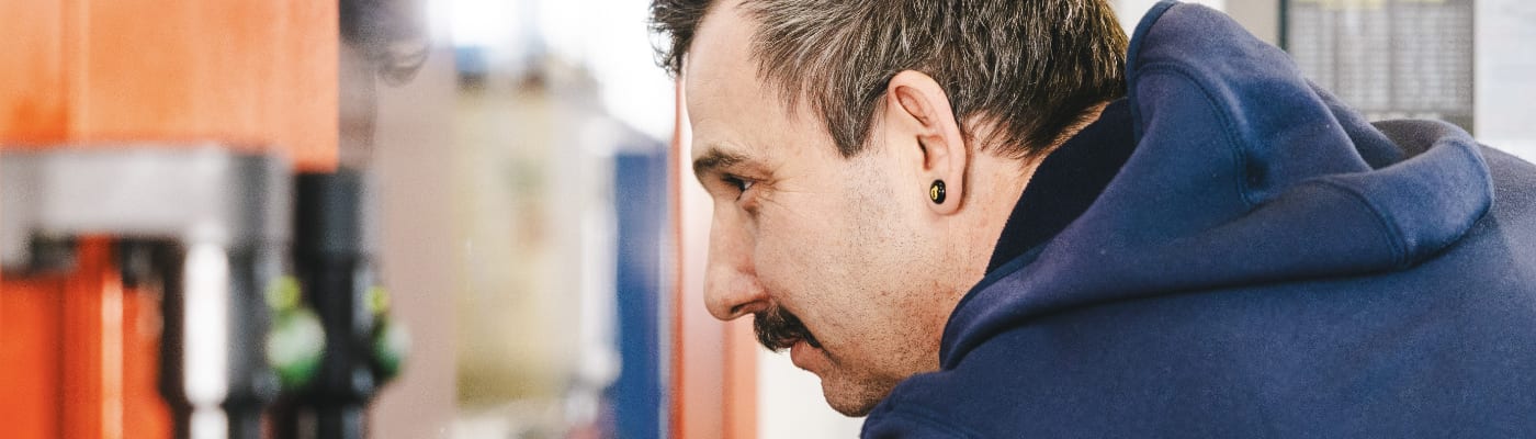 Ein Mann kontrolliert etwas mit präzisem Blick